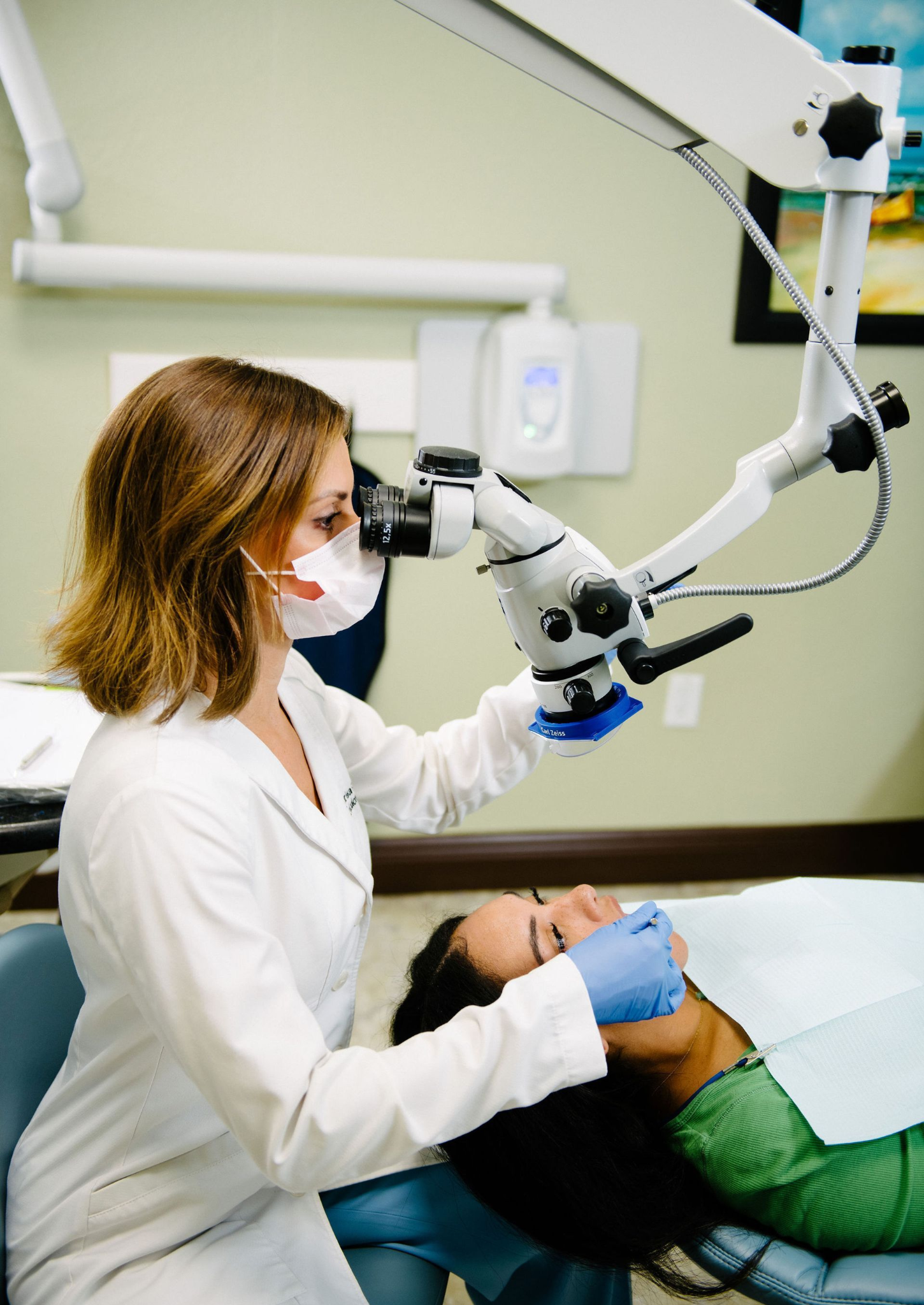 Dentist using surgical microscope for dental treatment