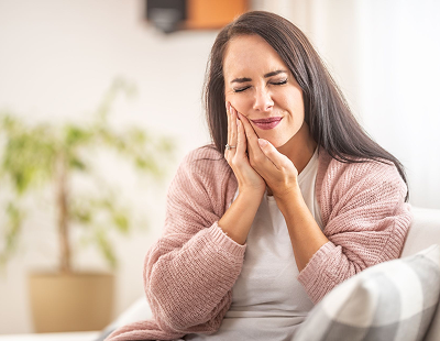 Woman clutching cheek from toothache