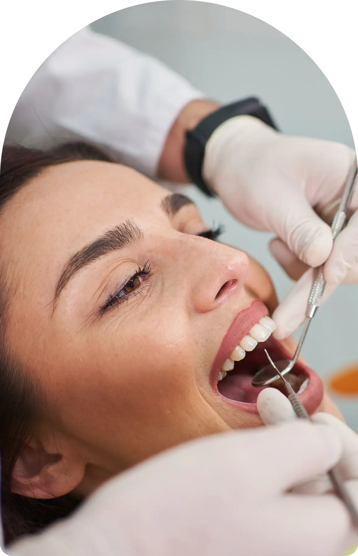 Woman receiving dental check-up with tools.