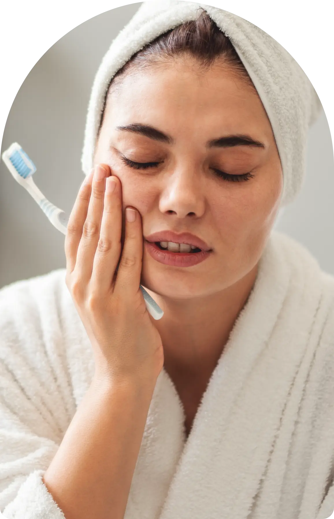 Woman with toothache holding toothbrush.